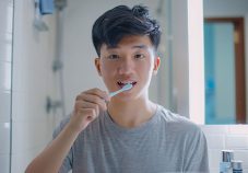 young-singaporean-man-brushing-his-teeth-to-maintain-healthy-teeth-and-gums-for-oral-hygiene-and-a-bright-smile