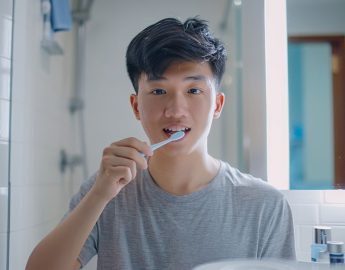 young-singaporean-man-brushing-his-teeth-to-maintain-healthy-teeth-and-gums-for-oral-hygiene-and-a-bright-smile